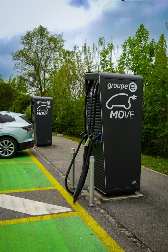 Electric vehicle charging station outdoors surrounded by nature, promoting sustainable travel.