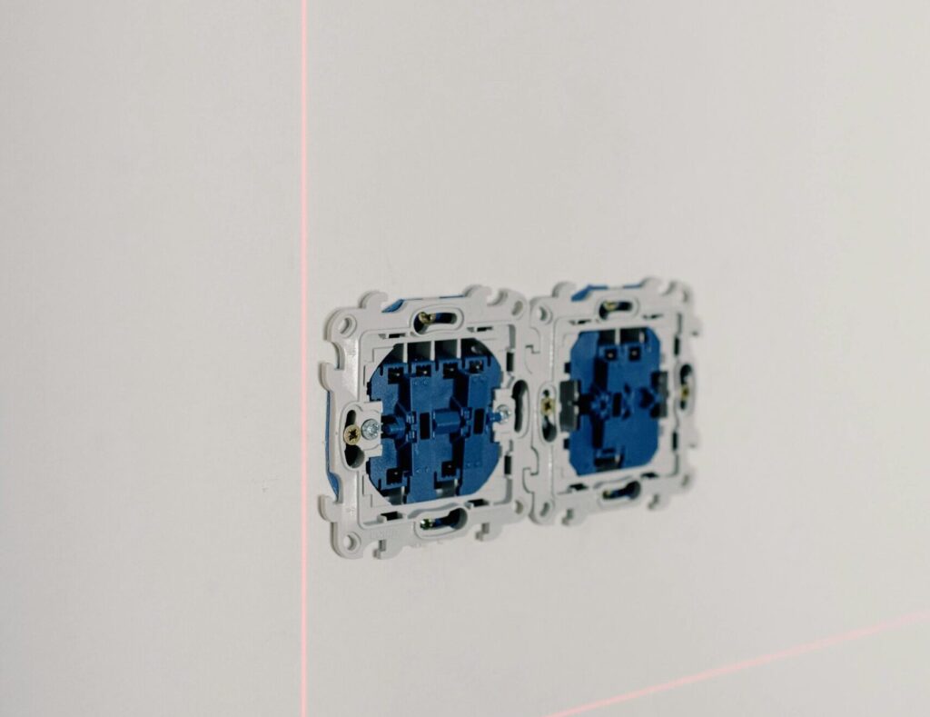 Open sockets with electricity system on white tile wall in room at home
